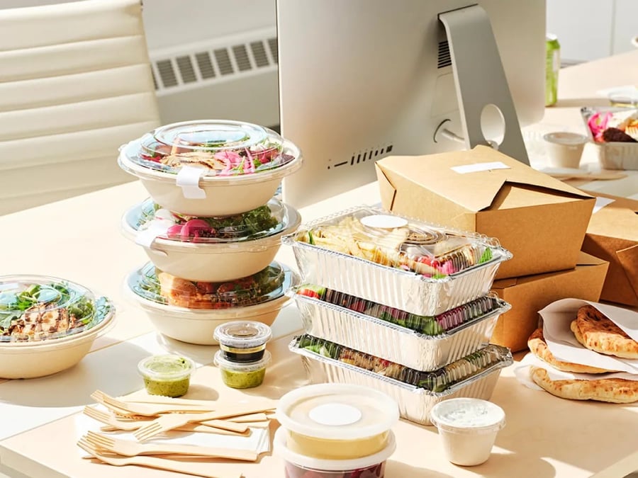 Colleagues laughing together over lunch in the office